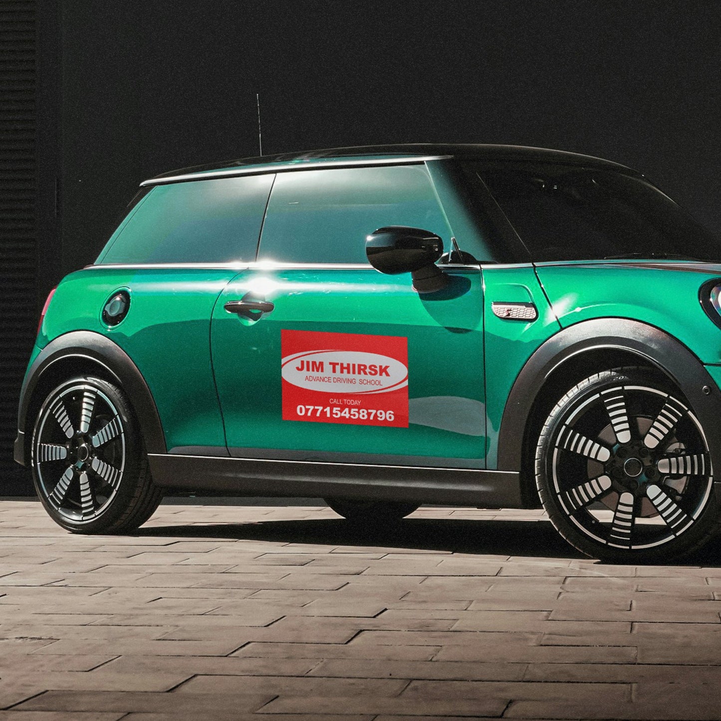 Magnetic Sign shown on the drivers door of a green mini car