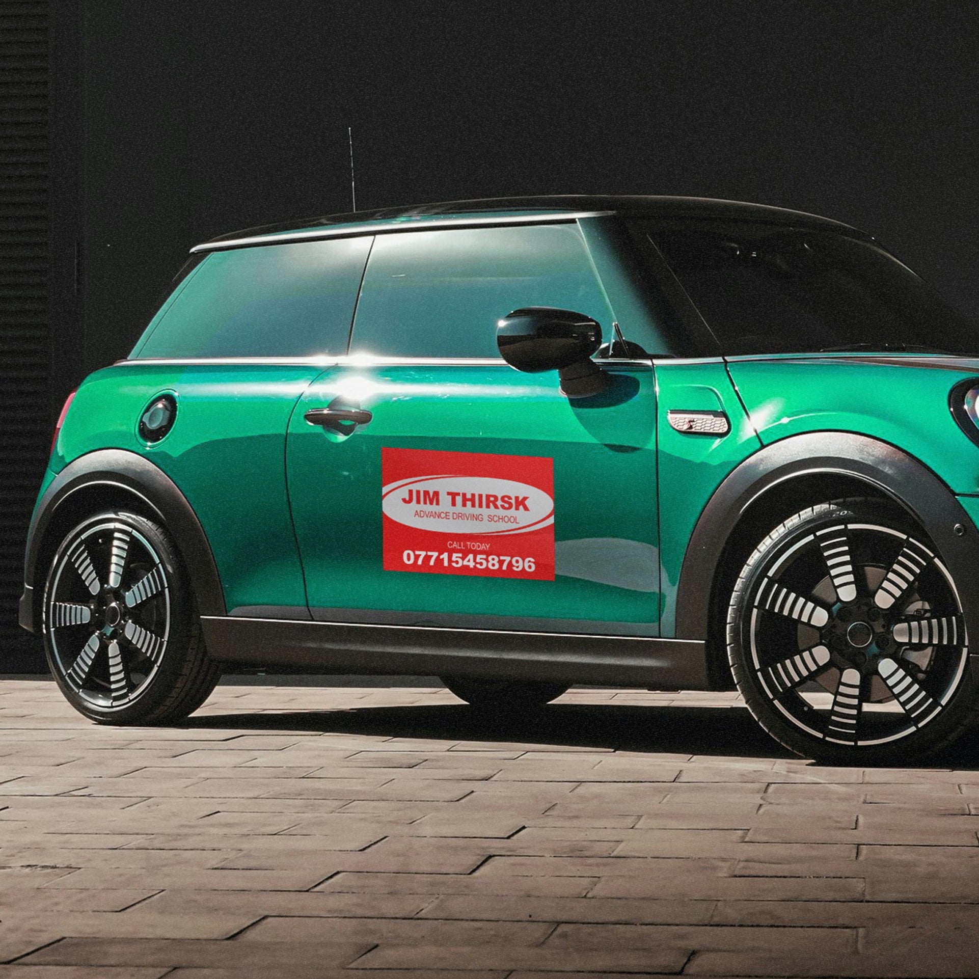 Magnetic Sign shown on the drivers door of a green mini car